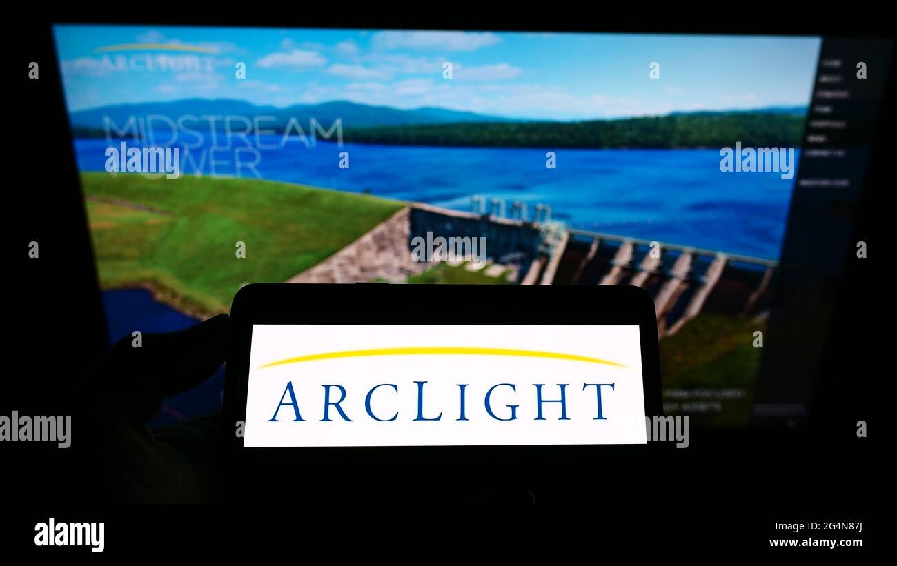 Persona che detiene smartphone con logo della società di investimento statunitense ARCLIGHT Capital Partners LLC sullo schermo di fronte al sito web. Mettere a fuoco il display del telefono. Foto Stock