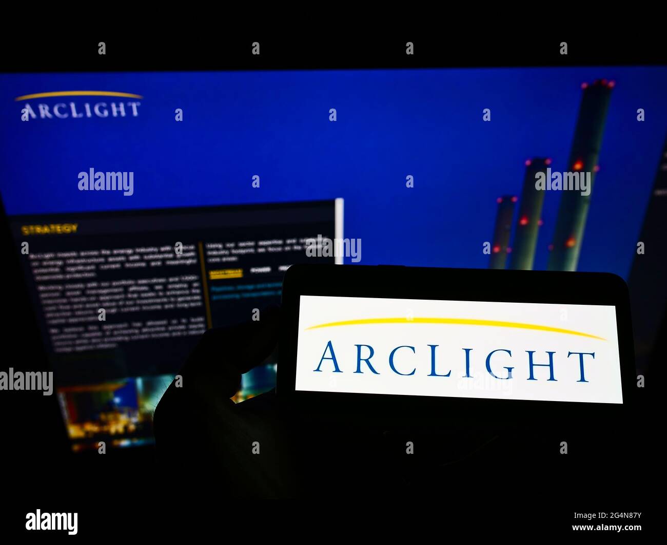 Persona che detiene il telefono cellulare con il logo della società di investimento statunitense ARCLIGHT Capital Partners LLC sullo schermo davanti alla pagina web. Mettere a fuoco il display del telefono. Foto Stock
