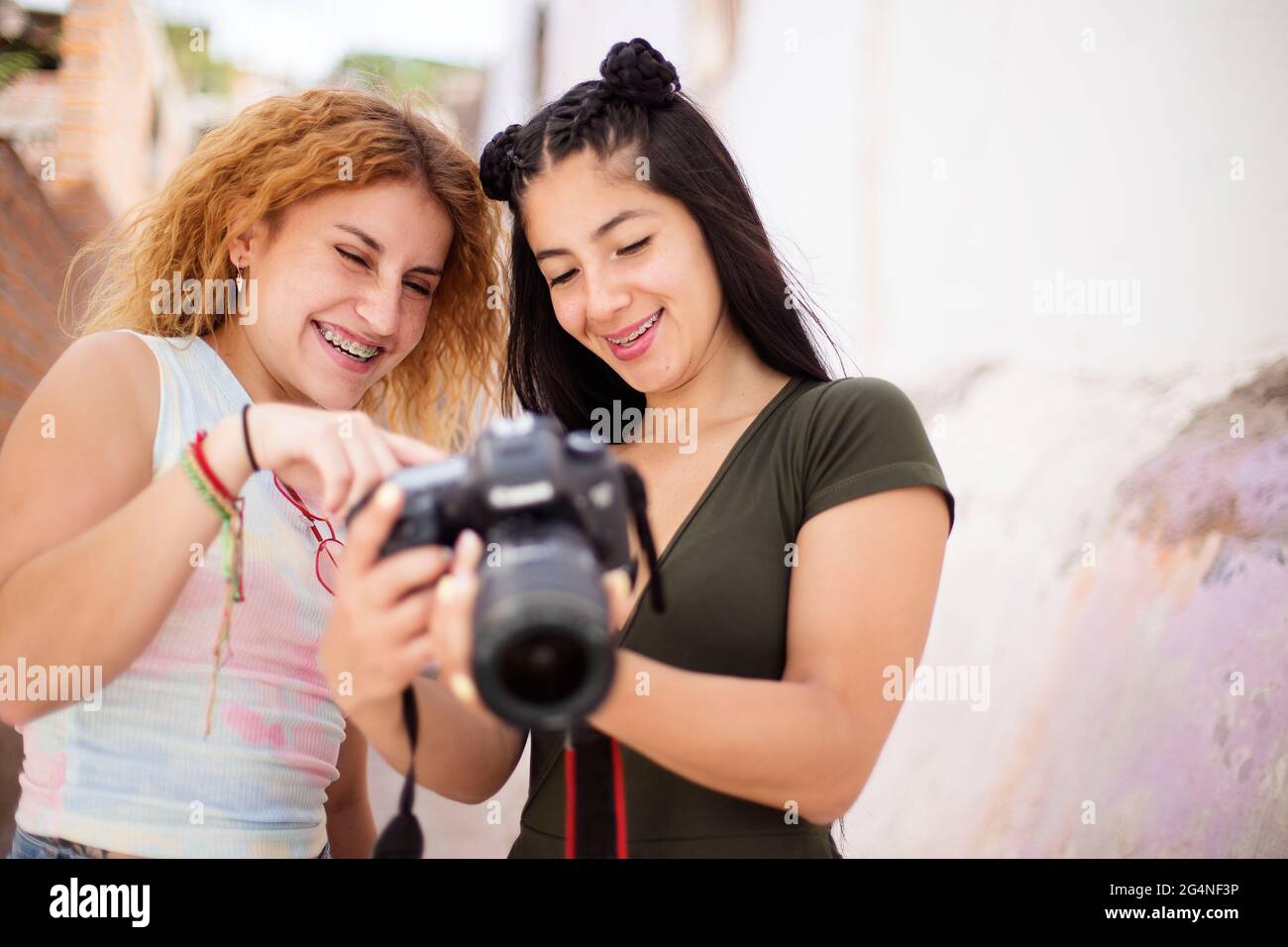 due amici donne che guardano il display di una fotocamera dslr Foto Stock