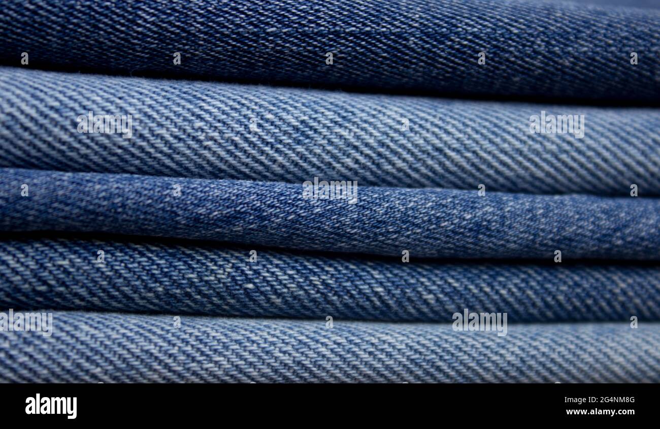 Una pila di denim. Texture in primo piano in denim colorato. Foto Stock