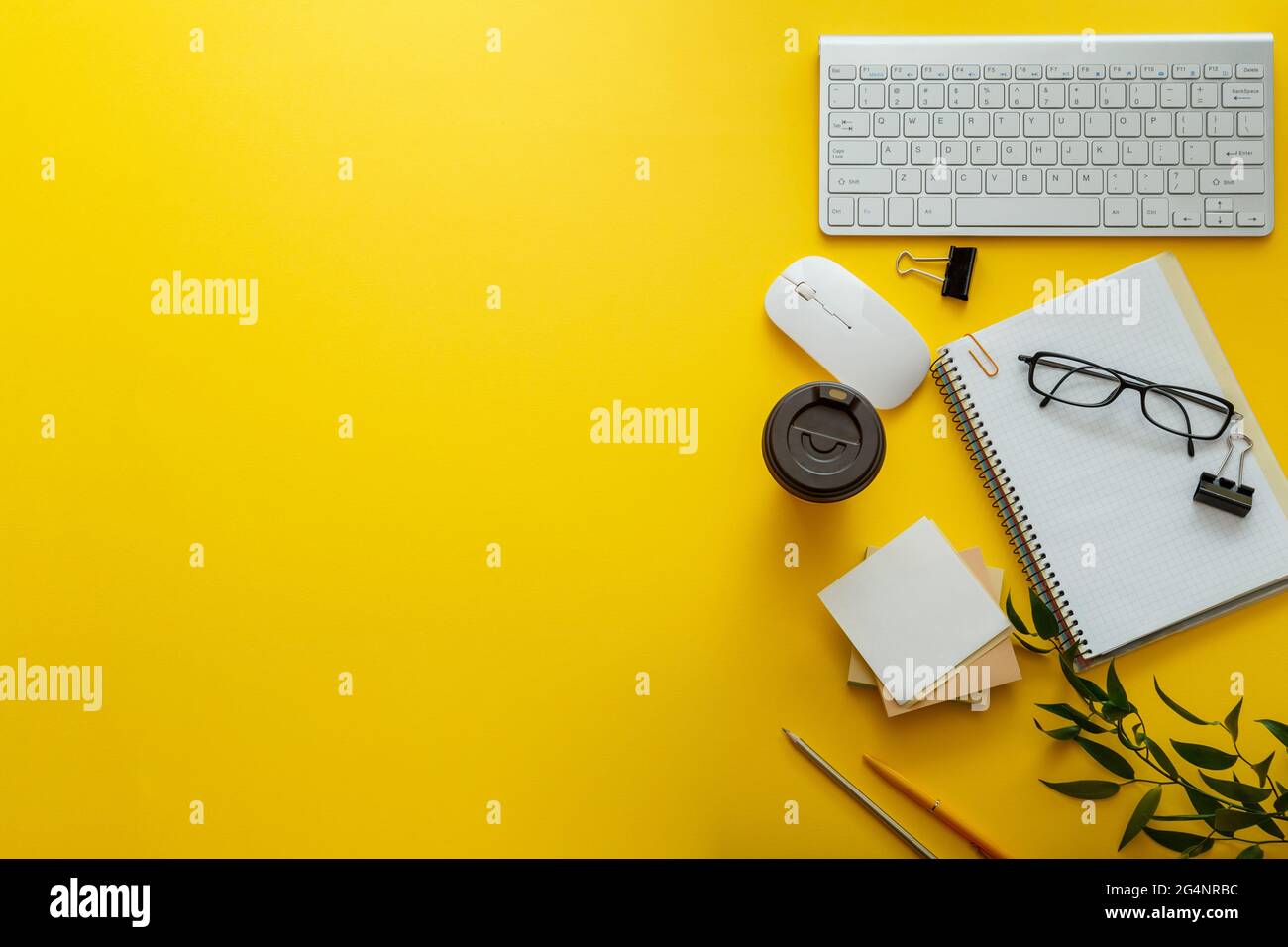 Spazio di lavoro con disposizione della scrivania con tastiera per pc note bicchieri da caffè bicchieri di colore giallo luminoso sfondo spazio per la copia. Moderna scrivania da ufficio con area di lavoro piatta Foto Stock