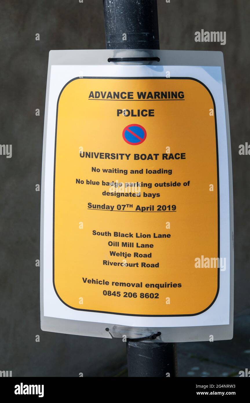 Un cartello della polizia a Hammersmith avverte di limitazioni al parcheggio durante la corsa in barca. Foto Stock