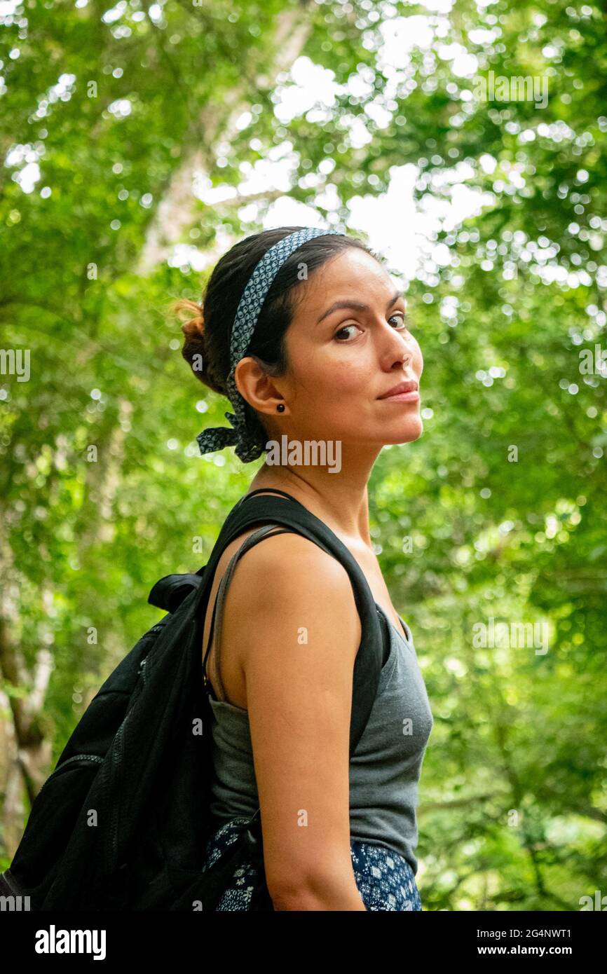 Latin Woman camminando nel mezzo della natura e guardando la macchina fotografica Foto Stock