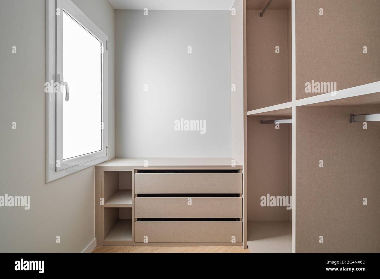 Nuovi mobili da incasso in un piccolo spogliatoio. Ripostiglio moderno e  vuoto con armadio, cassetti e molto spazio per appendiabiti Foto stock -  Alamy