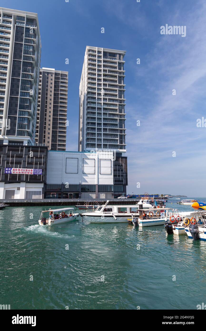 Kota Kinabalu, Malesia - 17 marzo 2019: Barche a motore con passeggeri sono vicino al terminal dei traghetti di Jesselton Point in una giornata di sole. Foto verticale Foto Stock