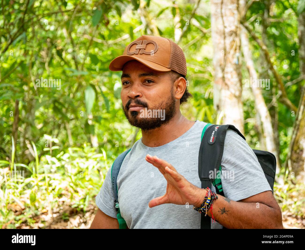Minca, Magdalena, Colombia - 19 2021 maggio: L'uomo latino bruno con la sua pelle indossa un cappuccio e si trova nella foresta circondata da un lotto di natura Foto Stock