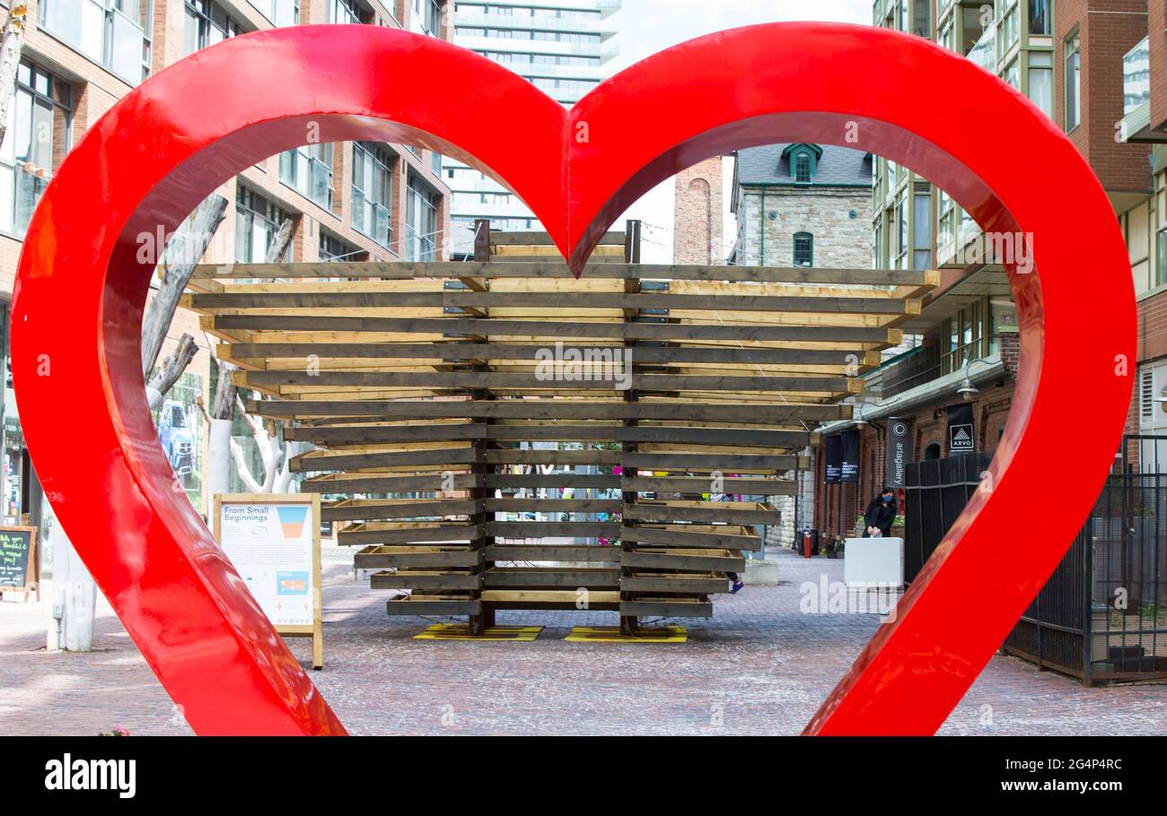 Toronto, Canada. 22 Giugno 2021. Un'installazione d'arte è vista attraverso una scultura a cuore rosso durante l'esposizione del concorso internazionale di design 2021 Winter Stations a Toronto, Canada, il 22 giugno 2021. Credit: Zou Zheng/Xinhua/Alamy Live News Foto Stock