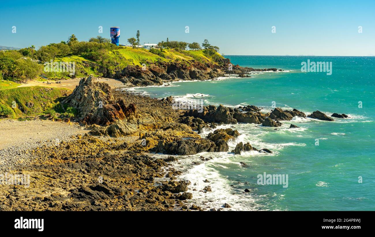 Litorale roccioso a Slade Point con una torre d'acqua sullo sfondo, Queensland, Australia Foto Stock