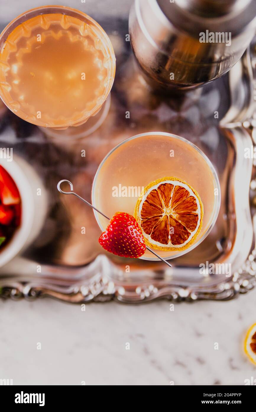 Cocktail estivi all'arancia e alla fragola serviti su un piatto di portata in metallo vintage. Foto Stock