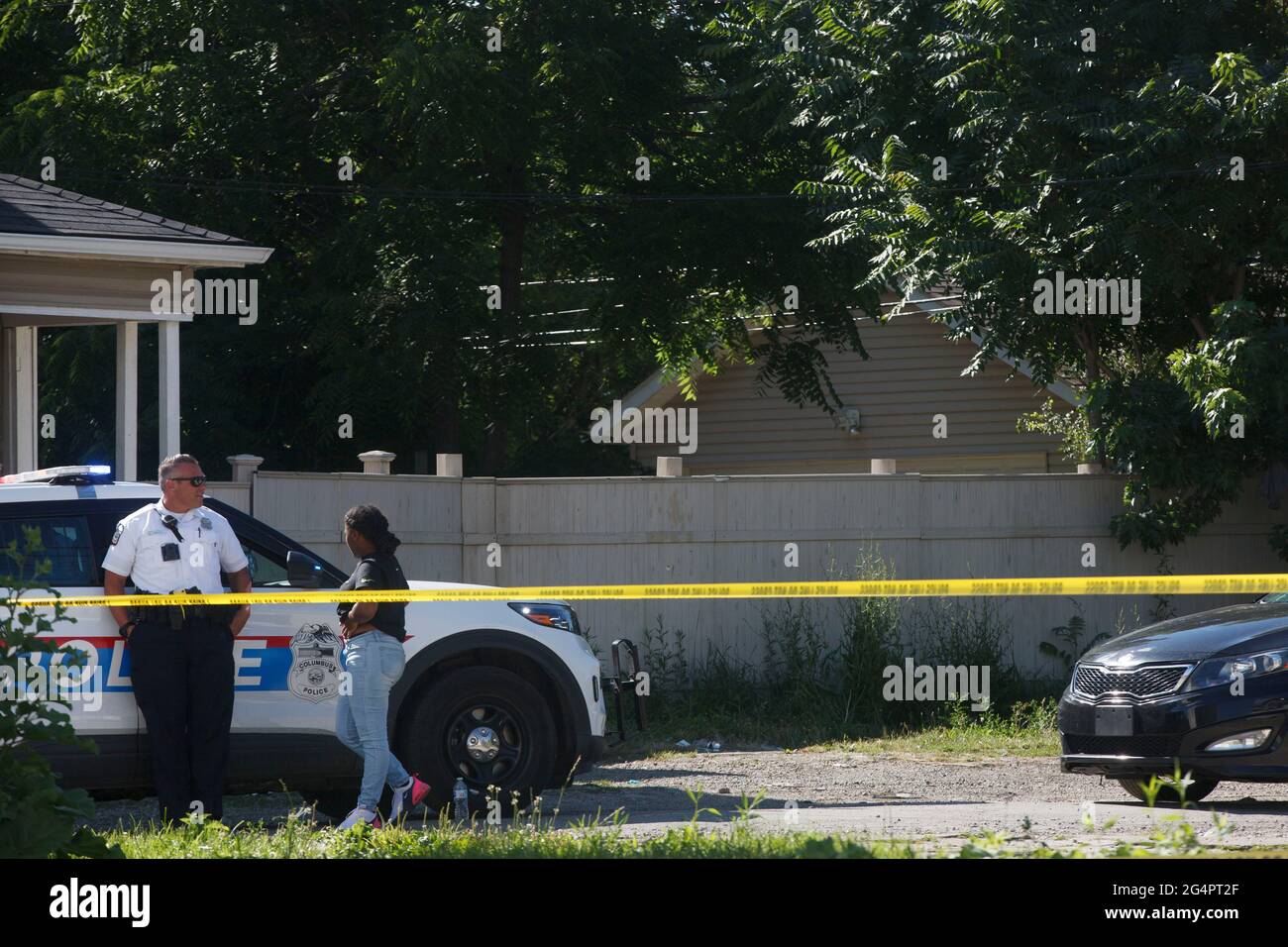 Columbus, Stati Uniti. 22 Giugno 2021. Una donna si trova vicino all'ufficiale della polizia di Columbus dietro il nastro della polizia. Una polizia ha coinvolto sparare si è verificato vicino all'intersezione di Cleveland Ave. E E. 21st Ave. A Columbus, Ohio. La polizia di Columbus riferisce che nessuno è stato ucciso nel tiro, ma l'Ohio Bureau of Criminal Investigations è stato chiamato per indagare la sparatoria. Credit: SOPA Images Limited/Alamy Live News Foto Stock