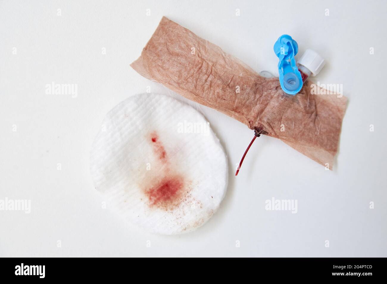 Catetere, bendaggio e tampone di cotone usati con sangue su sfondo bianco Foto Stock