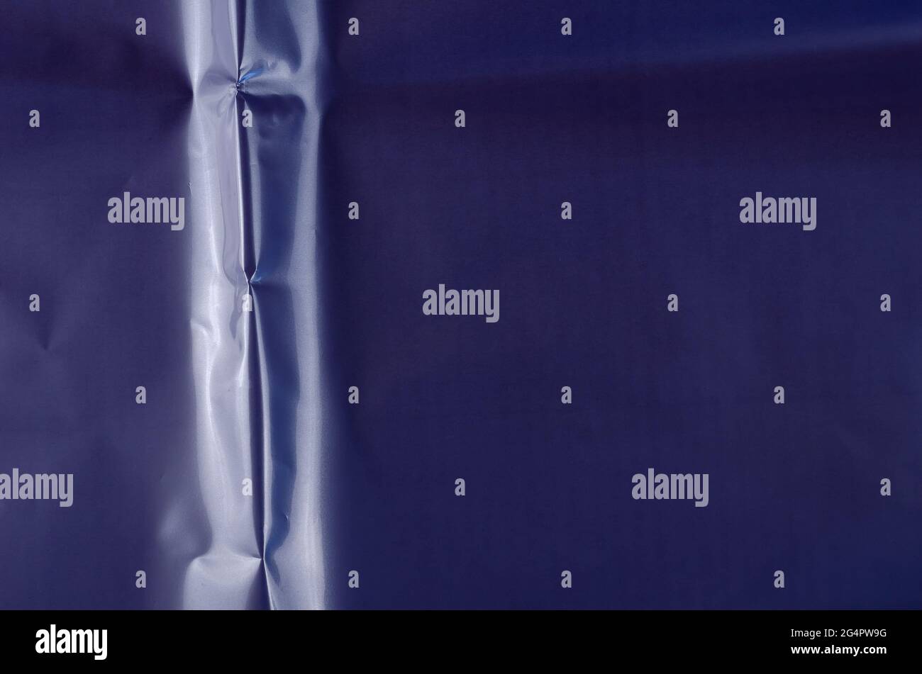 Superficie lucida con sbriciolamento blu. Immagine di una texture di imballaggio colorata. Sfondo astratto non uniforme con spazio copia. Foto Stock