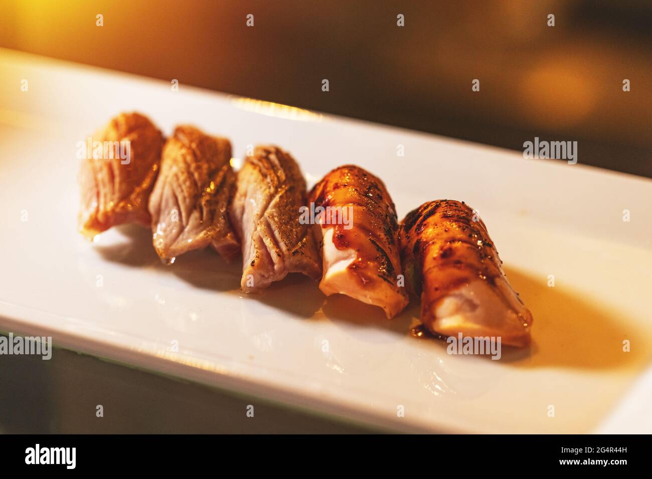 Sushi di salmone alla griglia servito sul piatto bianco, sushi su piatto caldo Foto Stock