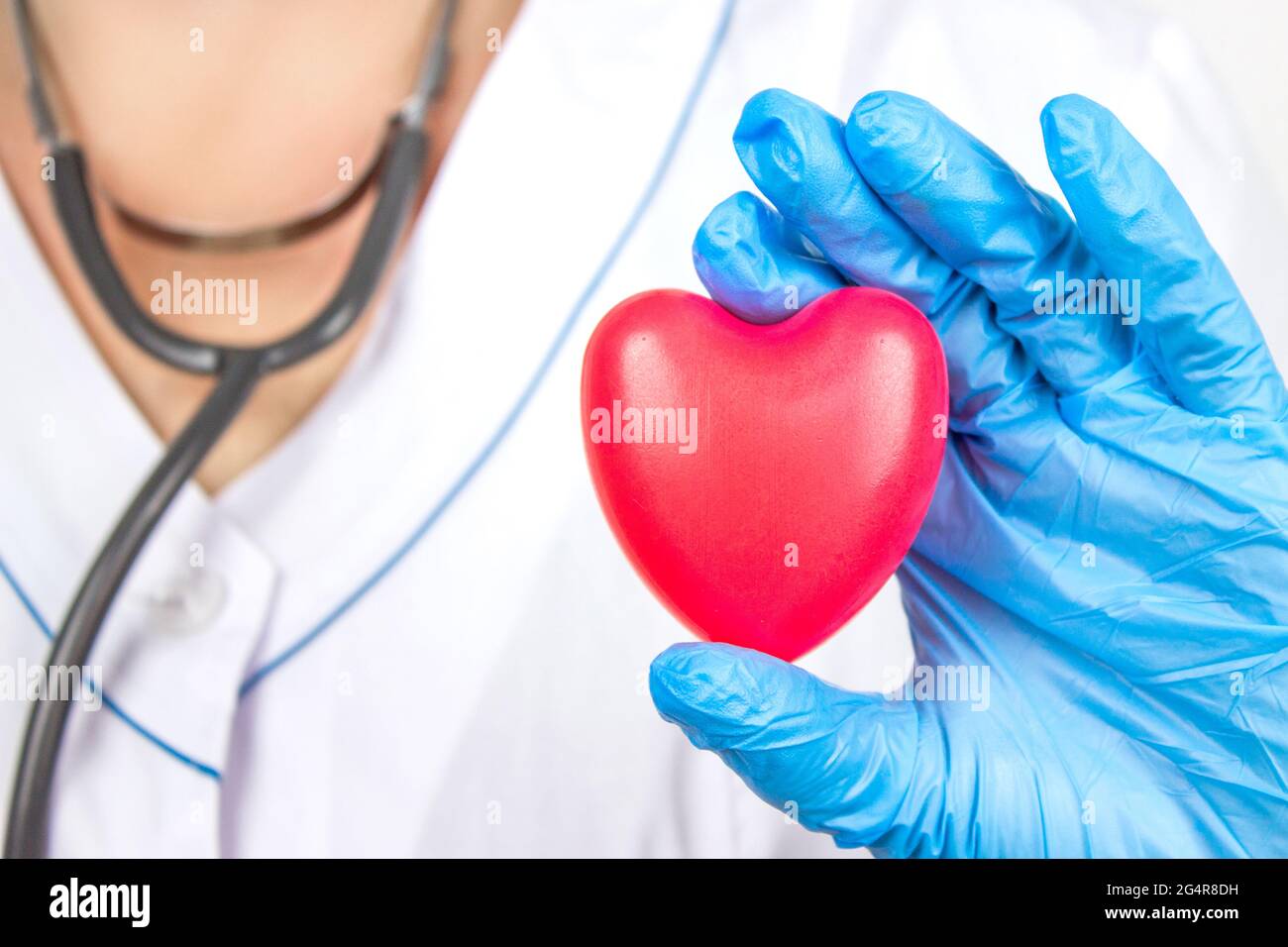 Ambulanza. Cardiologia Sanità. Primo piano mano del medico che tiene un cuore rosso all'ufficio dell'ospedale. Sanità e paziente, fallimento e malattie concetto Foto Stock