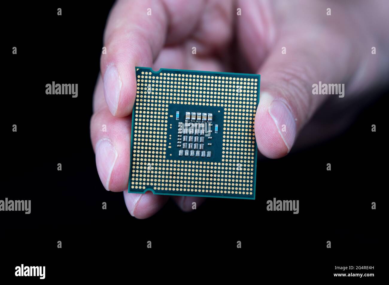 Mano che tiene la CPU su sfondo nero Foto Stock