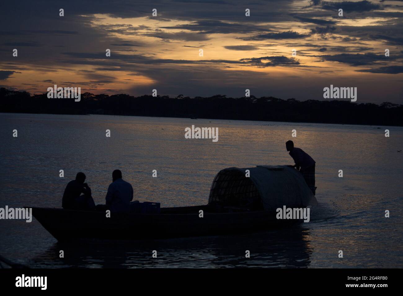 La sera la gente del villaggio sta attraversando il fiume in barca. Il luogo è Barisal distretto del Bangladesh Foto Stock