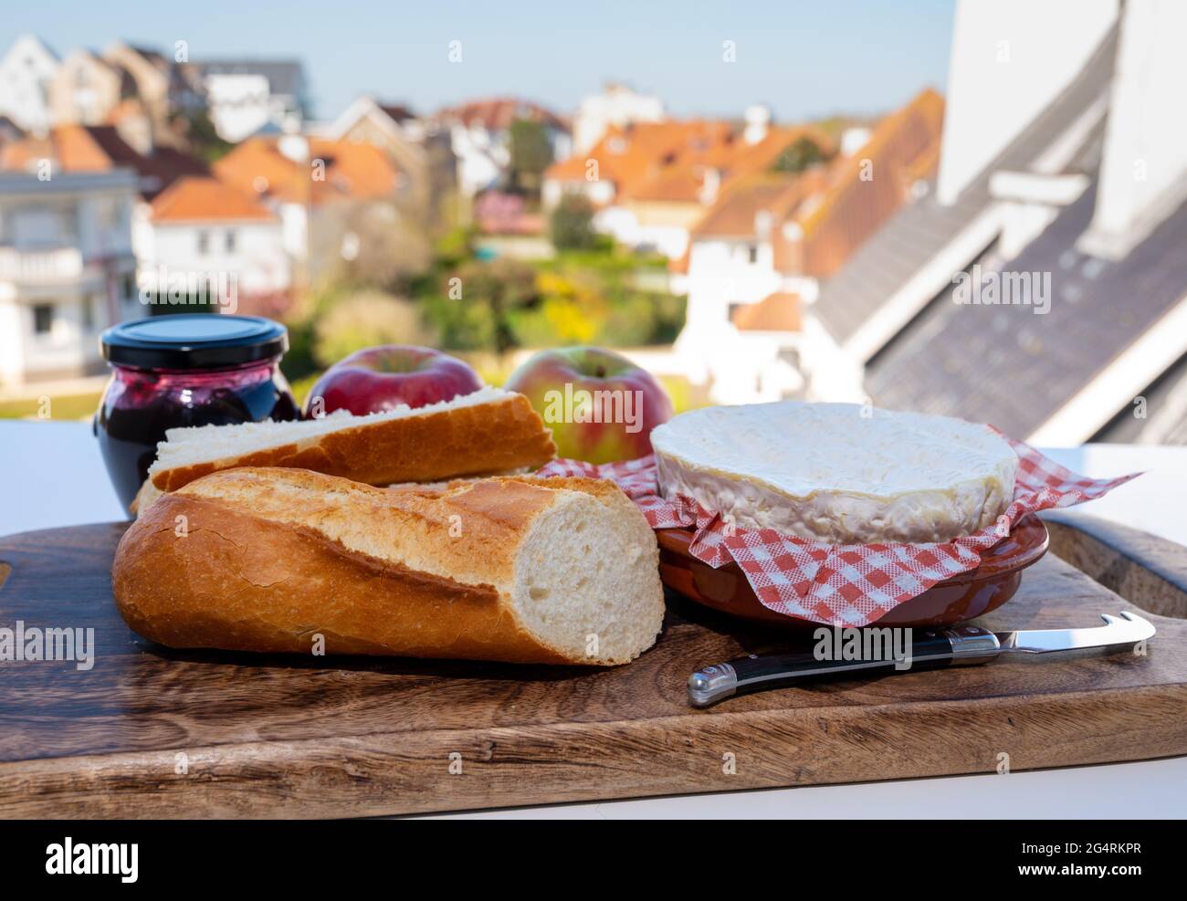 Colazione francese con pane baguette appena sfornato e camembert chee dalla Normandia, servita all'aperto con bella vista sul villaggio francese Foto Stock