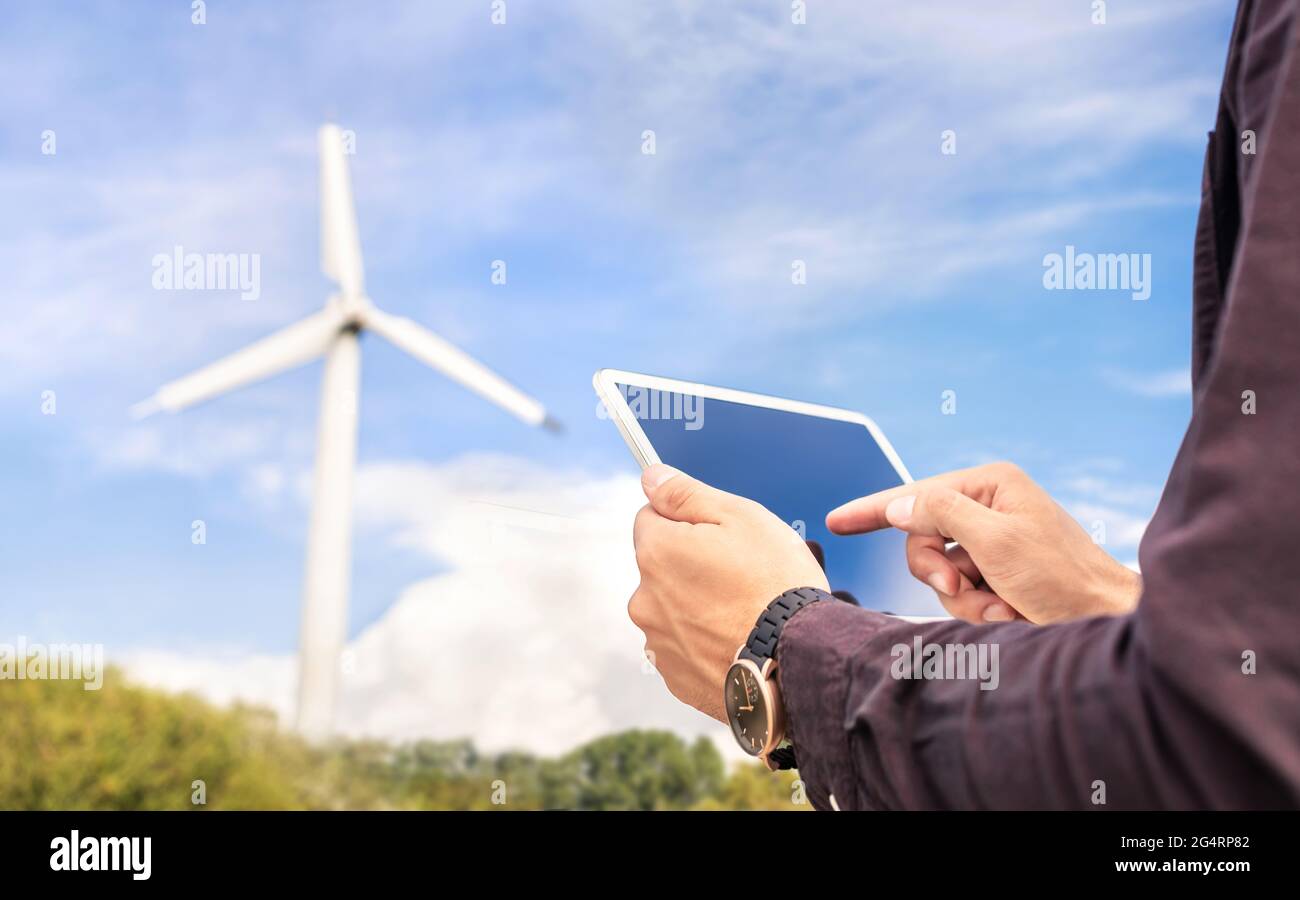 Lavoro sul campo con l'energia eolica e l'energia sostenibile con tablet. Ingegnere o tecnico nel settore della produzione di energia elettrica rinnovabile verde. Foto Stock