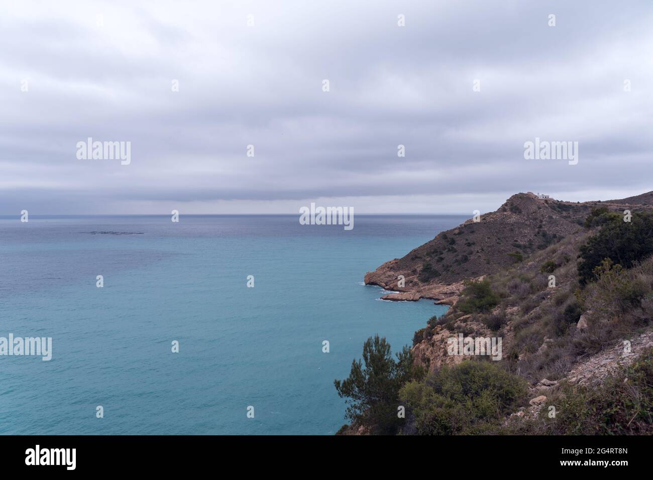 Vista panoramica della costa mediterranea, del Mar Mediterraneo, di un faro e di una fattoria di pesce, nel parco naturale della Sierra Helada a Benidorm, Foto Stock