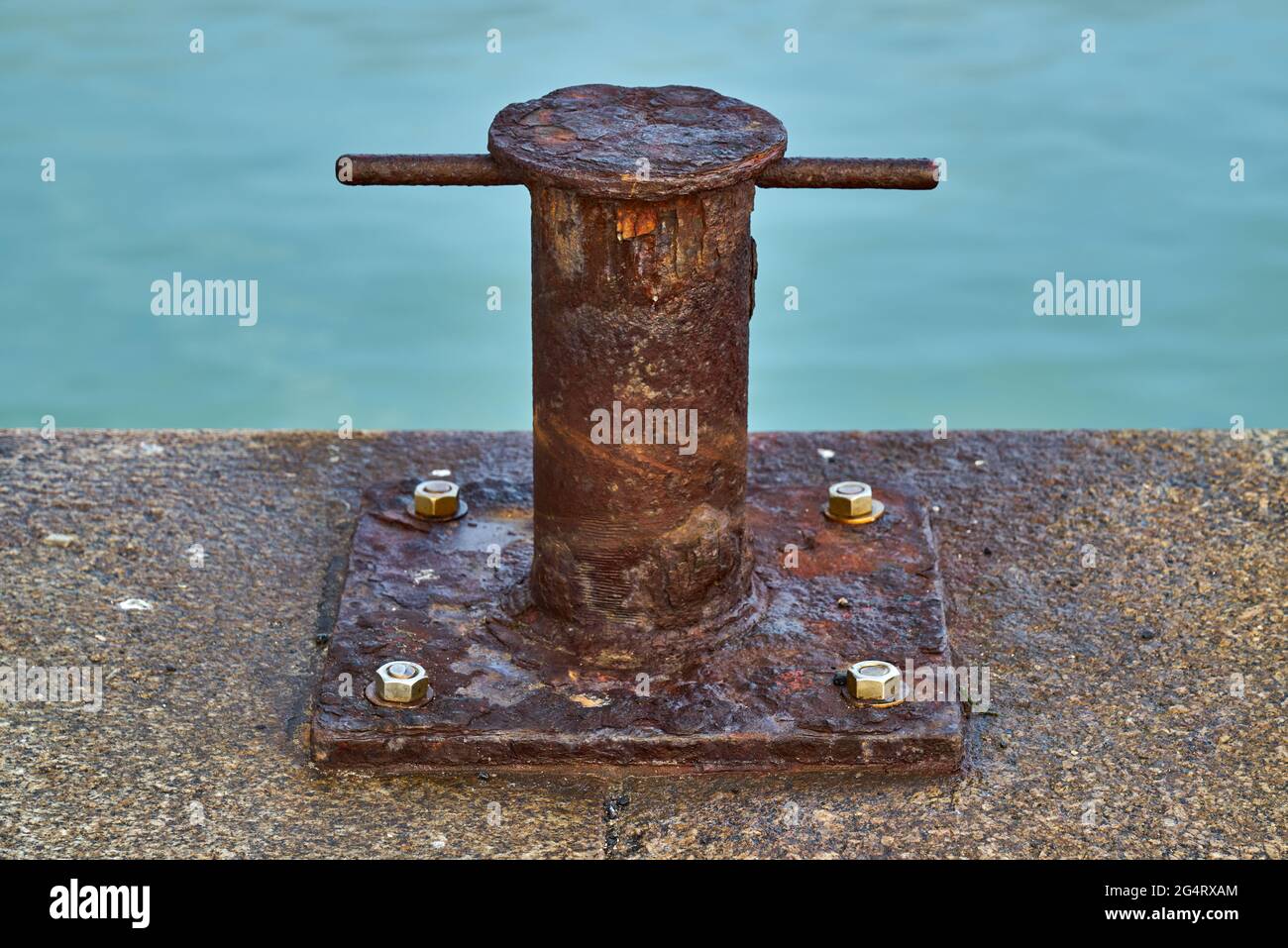 Un paletto samson fortemente arrugginito stile singolo bitt ormeggio per le barche Foto Stock