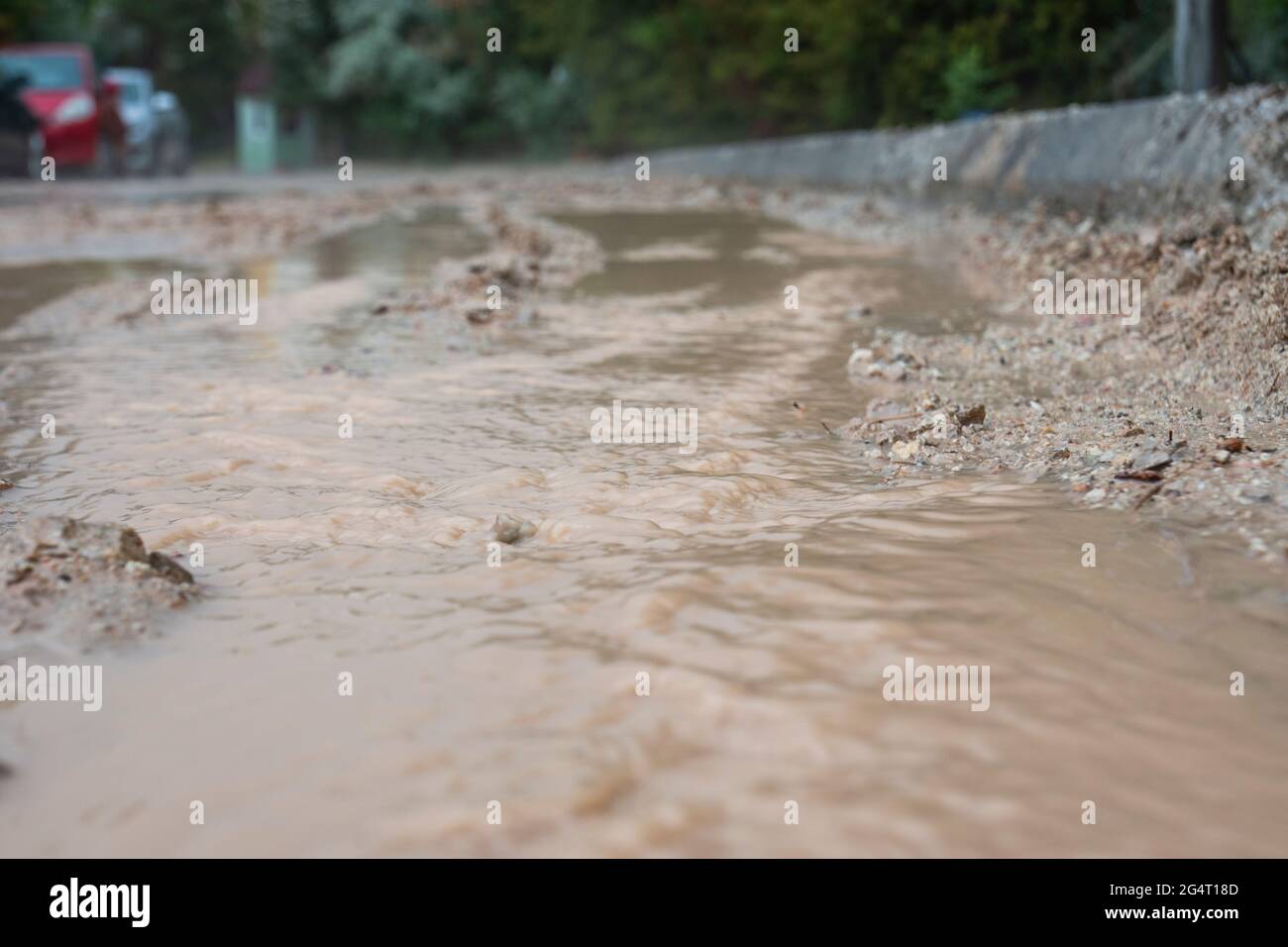 acqua fangosa che scorre dalle strade dopo la pioggia. Foto Stock