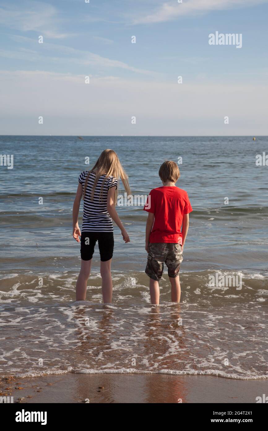 Giovane ragazzo e ragazza che si divertono in mare in una calda giornata estiva Foto Stock