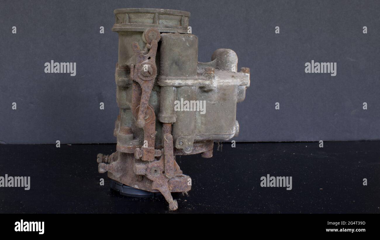 Un vecchio carburatore sporco contro uno sfondo nero Foto Stock Un vecchio carburatore sporco contro uno sfondo nero Foto Stock