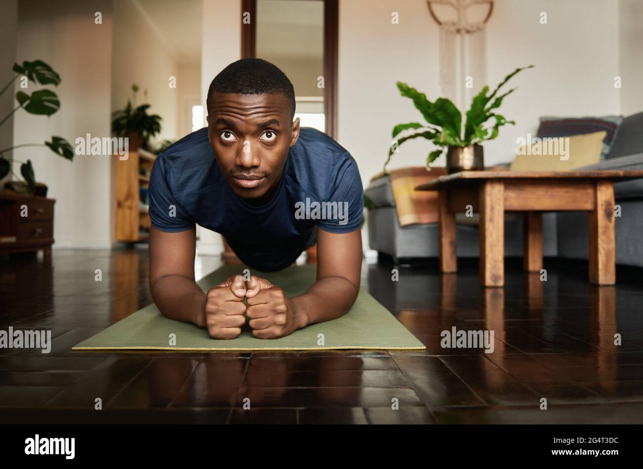 Giovane uomo africano che pianse durante una sessione di yoga a casa Foto Stock