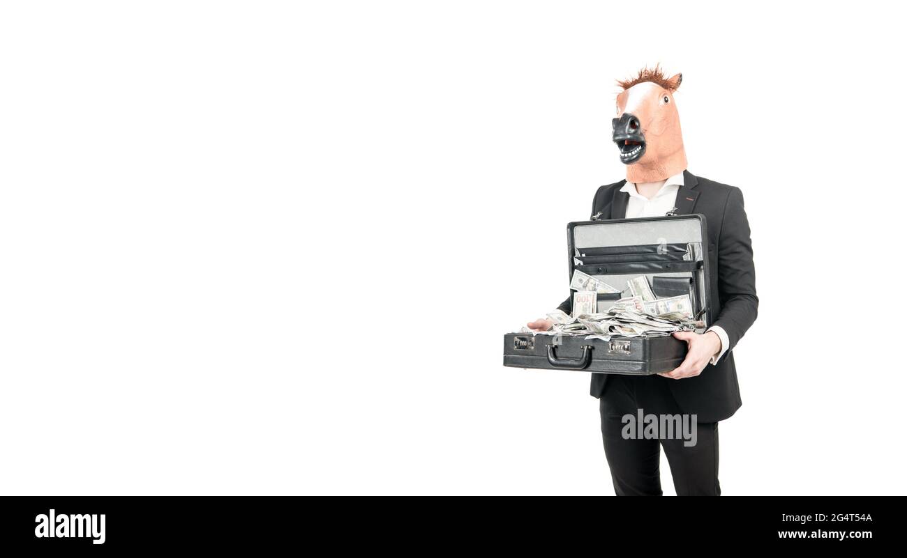 Uomo d'affari professionista indossare maschera testa cavallo tenendo valigia con banconote in dollari, denaro. Foto Stock