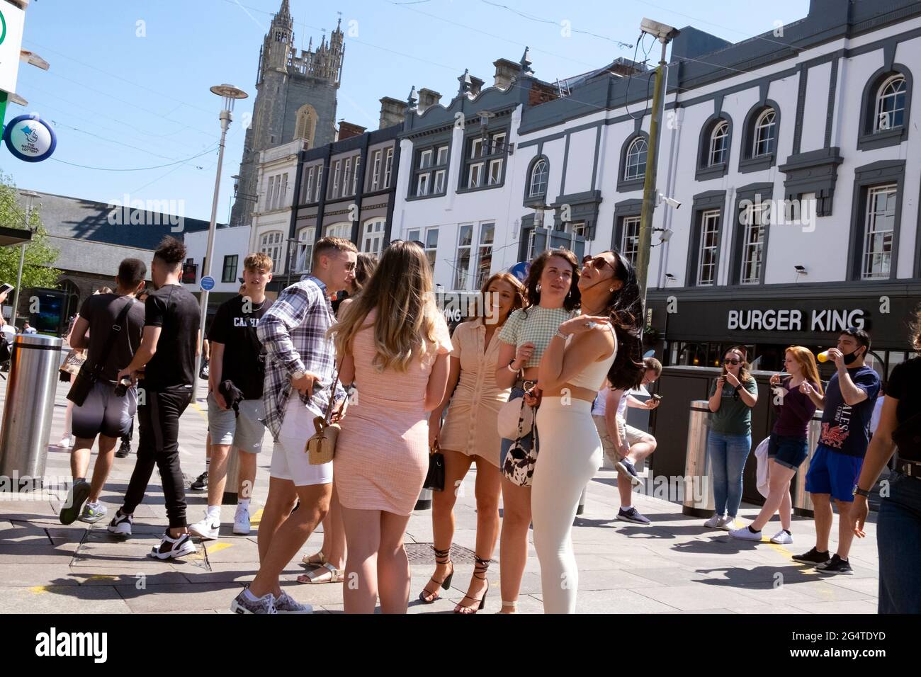 Giovani donne persone che si riuniscono sorridendo parlare godendo il sole dopo il blocco è alleviato in giugno estate Cardiff City Centre Wales UK KATHY DEWITT Foto Stock