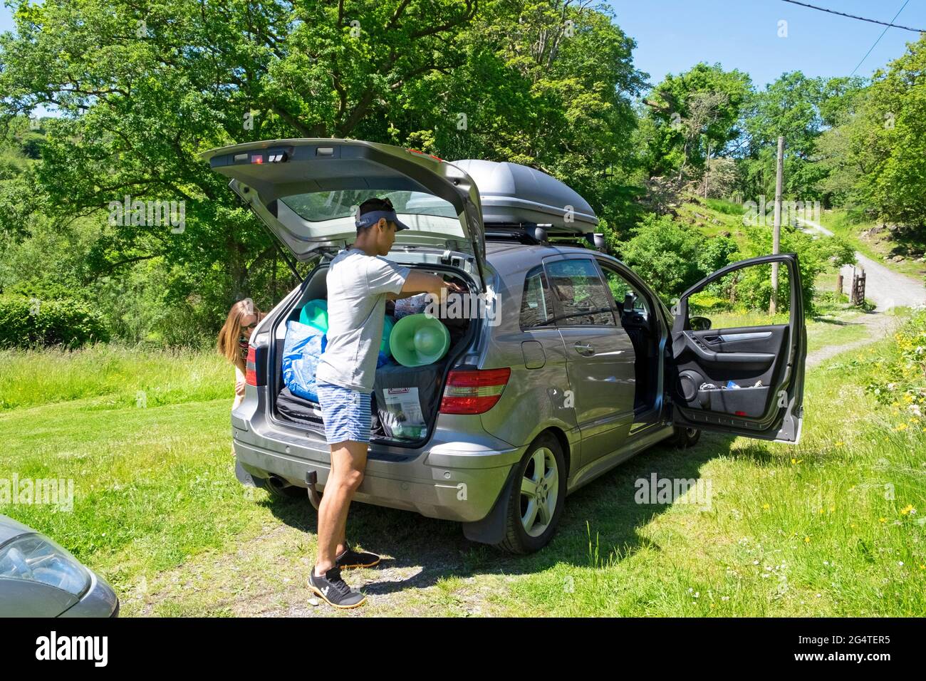 Auto di imballaggio della famiglia che si prepara per andare in vacanza staycation dopo covid 19 blocco pandemico eases 2021 in Galles UK KATHY DEWITT Foto Stock