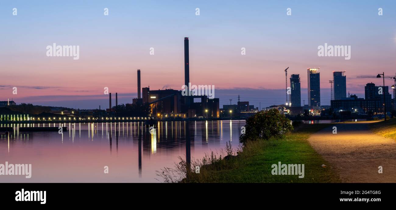 Helsinki / Finlandia - 22 GIUGNO 2021: Uno splendido skyline notturno della città contro il cielo colorato. Una vecchia centrale che getta riflessioni sull'acqua. Foto Stock