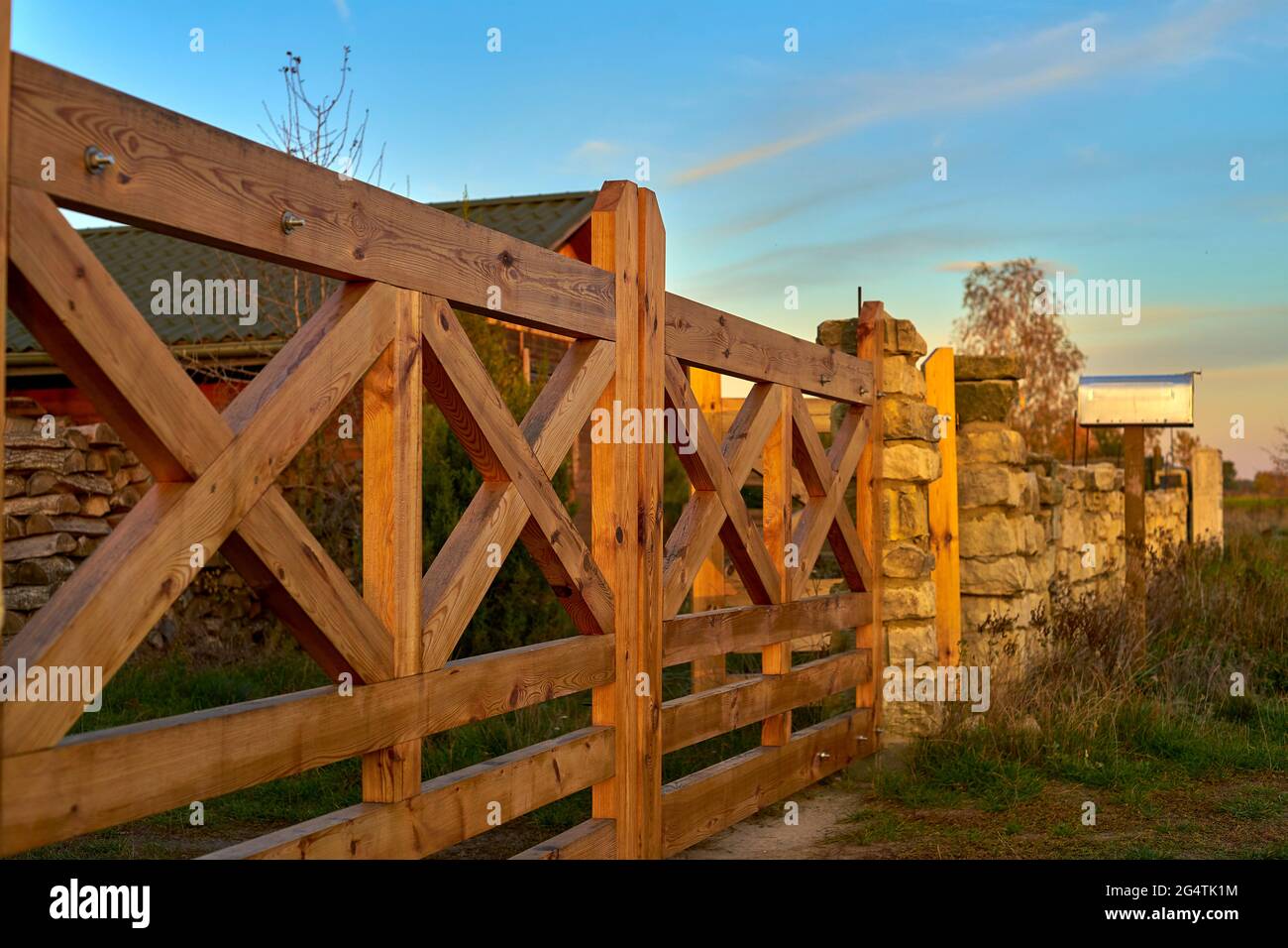 vista rurale di un cancello di legno e muro di pietra Foto Stock