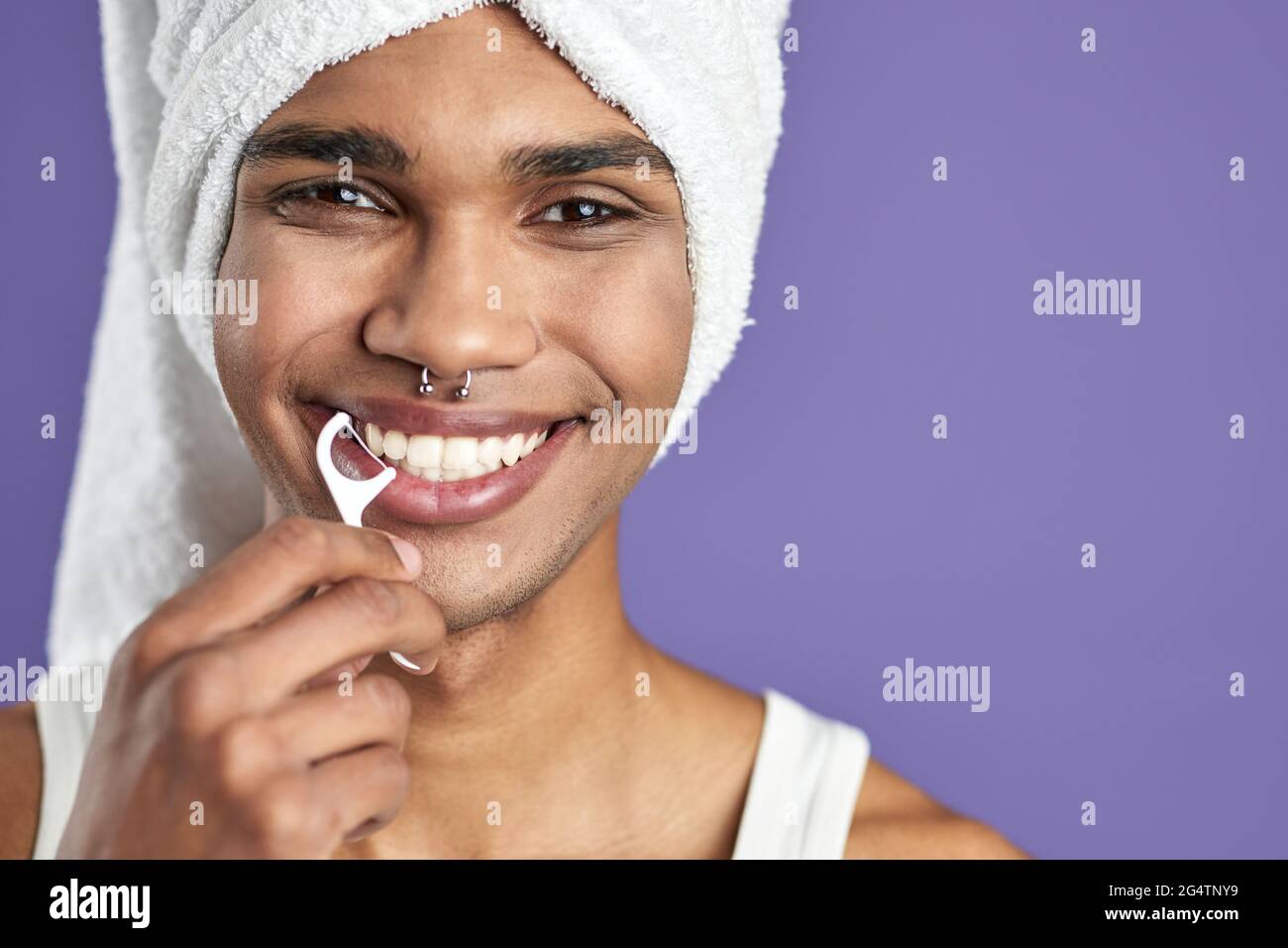 Uomo transgender con sorriso di filo interdentale su sfondo viola isolato ritratto del headshot Foto Stock