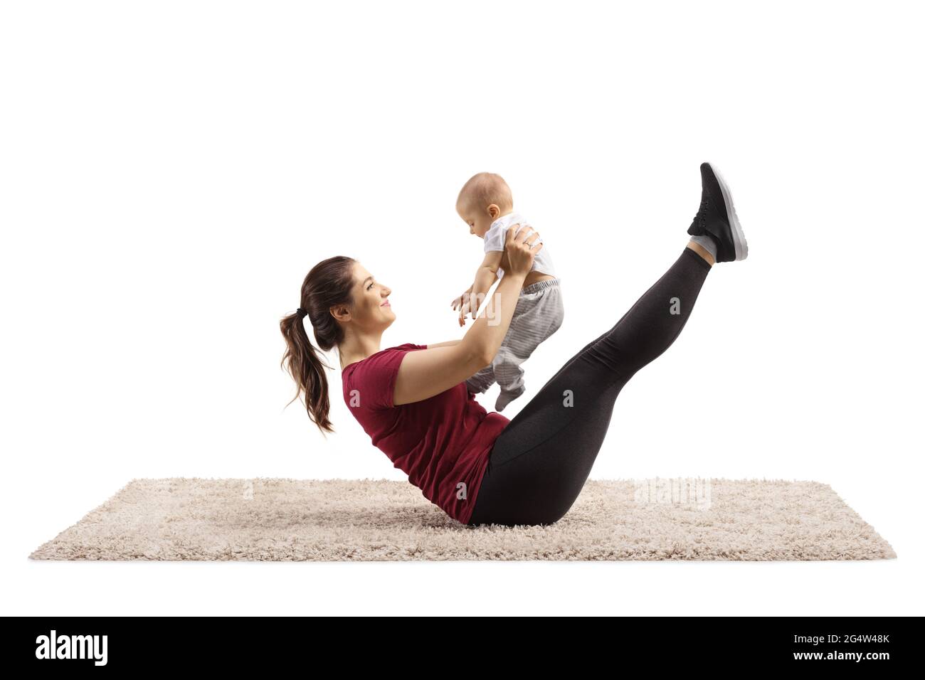 Madre che esercita l'abs e tiene il suo bambino isolato su sfondo bianco Foto Stock