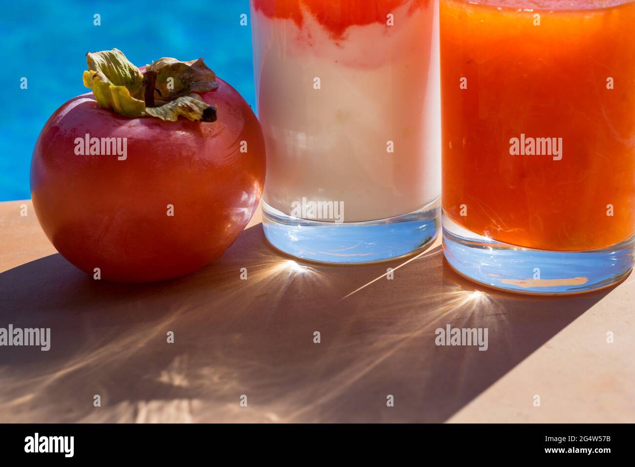 gustosa bevanda fresca di frutta al persimon a bordo piscina alla luce del sole Foto Stock