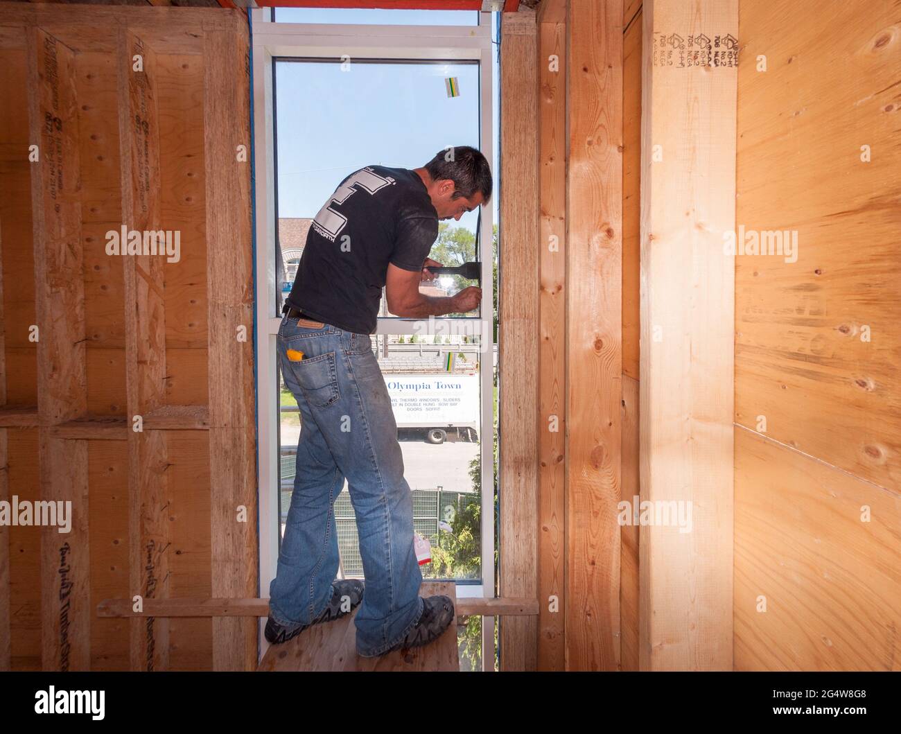 Operai edili che lavorano installando finestre di stile europeo in un cantiere di una casa privata. Foto Stock