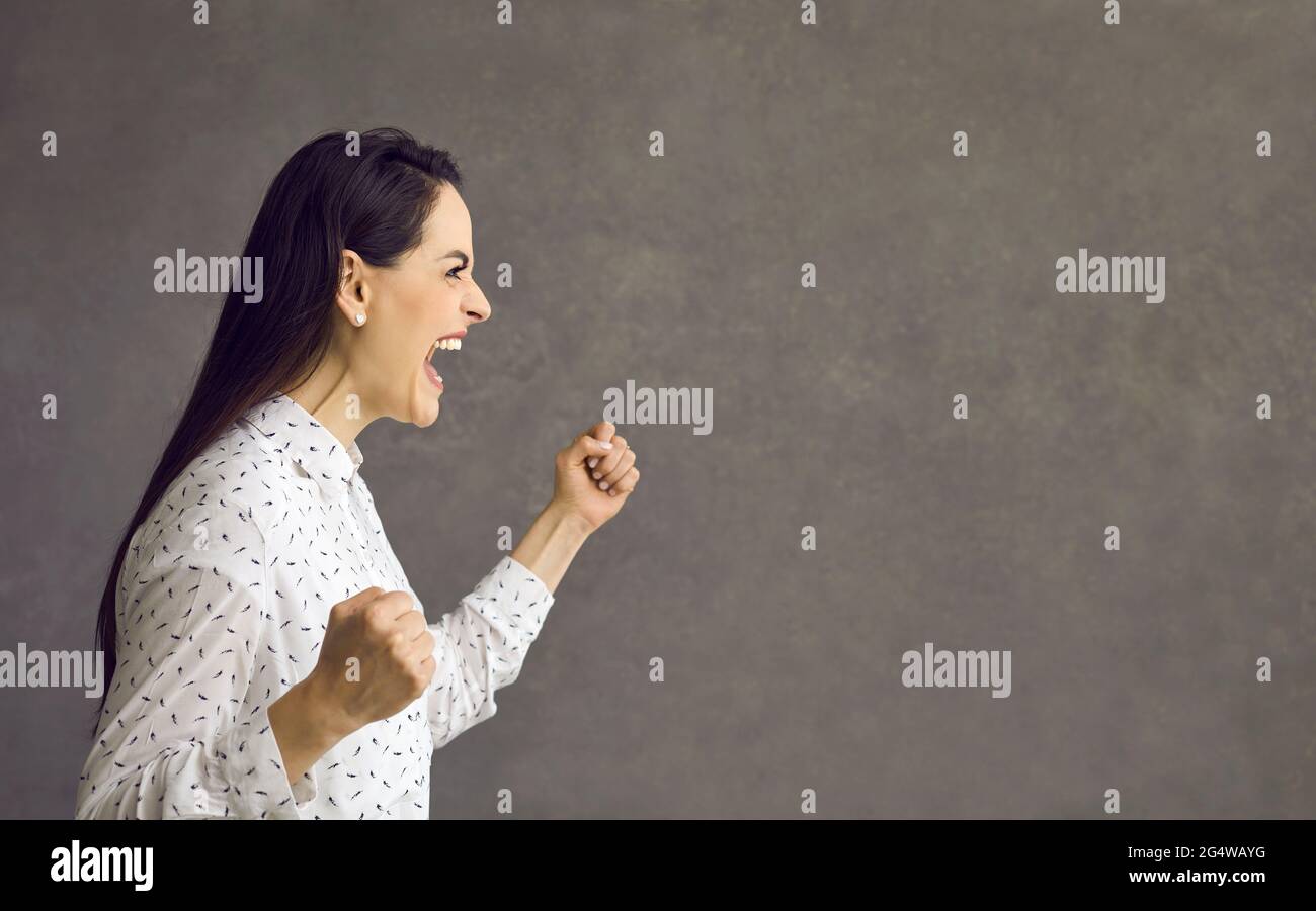 Giovane donna caucasica urlando mostrando furioso volto vista laterale ritratto Foto Stock