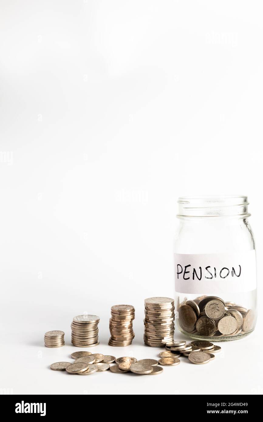 Monete accatastate accanto a un vaso vuoto con un'etichetta per il fondo pensione. Pensione, finanziaria, risparmio, economia, concetto di investimento Foto Stock