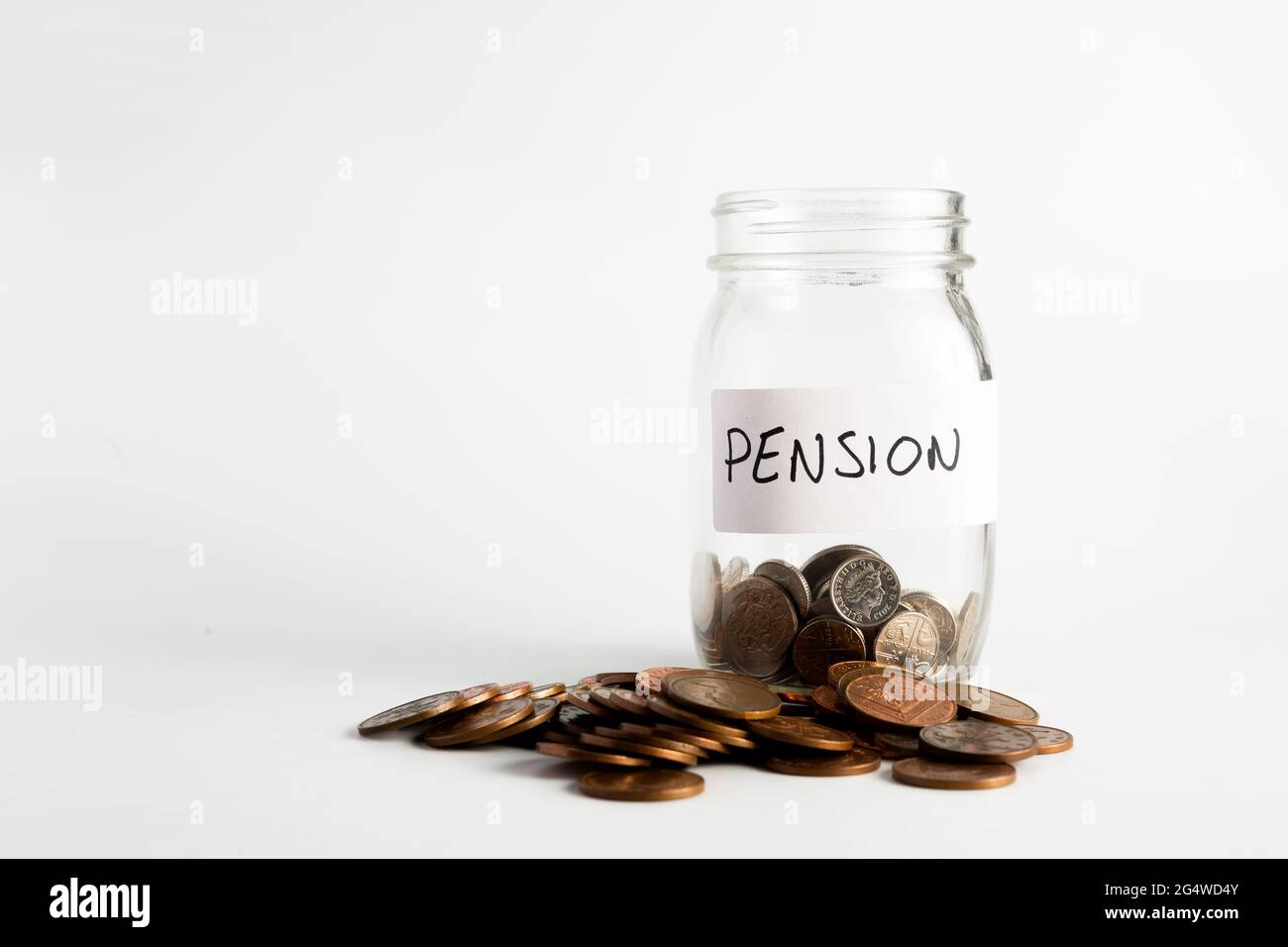 Monete accatastate accanto a un vaso vuoto con un'etichetta per il fondo pensione. Pensione, finanziaria, risparmio, economia, concetto di investimento Foto Stock
