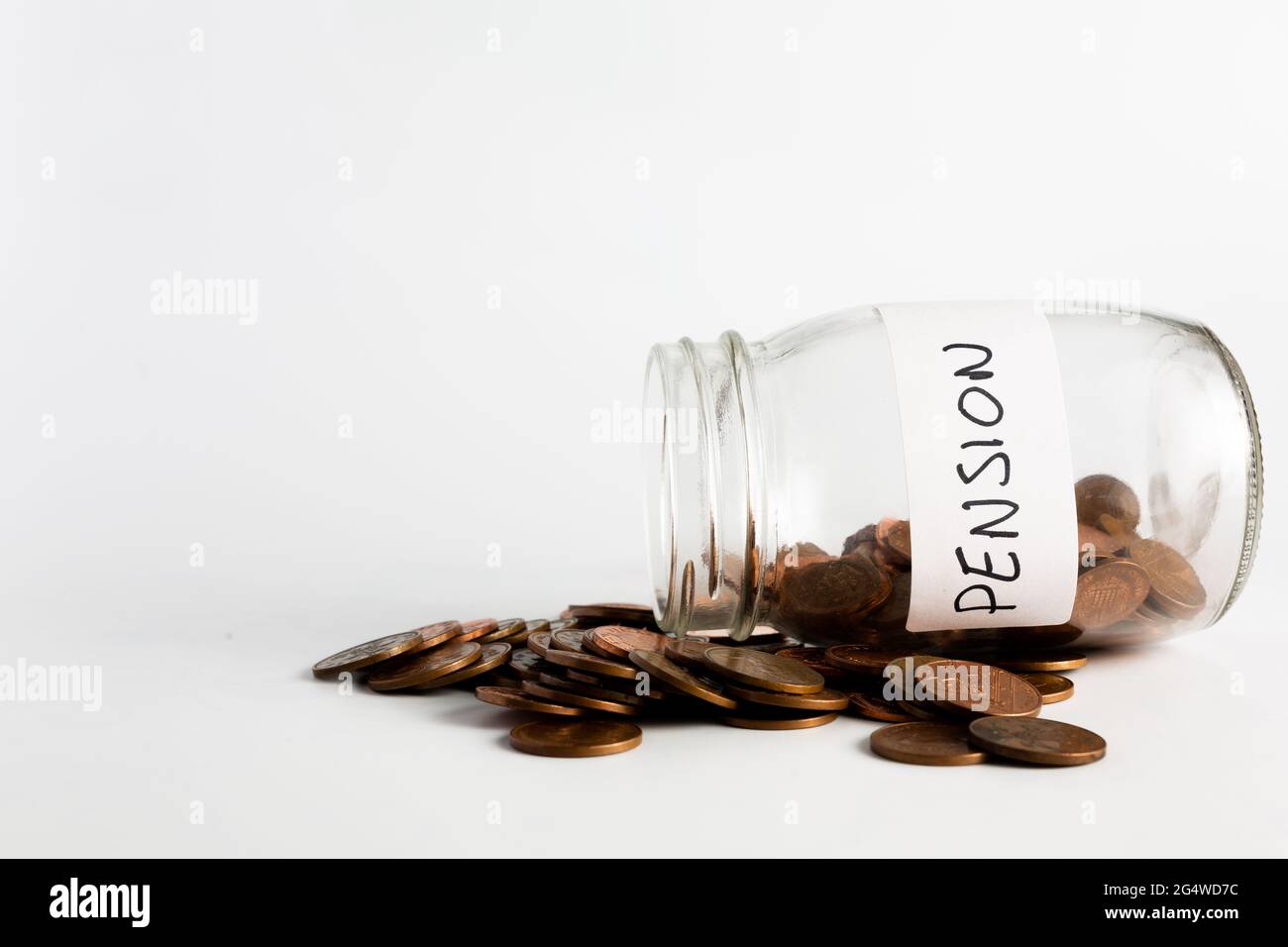 Monete di rame che fuoriescono da un vaso etichettato pensione. Pensione, finanziaria, risparmio, economia, concetto di investimento Foto Stock