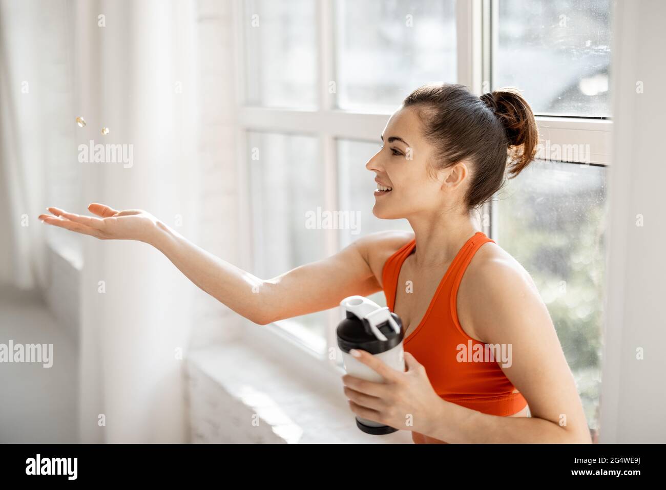 Donna sportiva prende integratori o vitamine in palestra Foto stock - Alamy