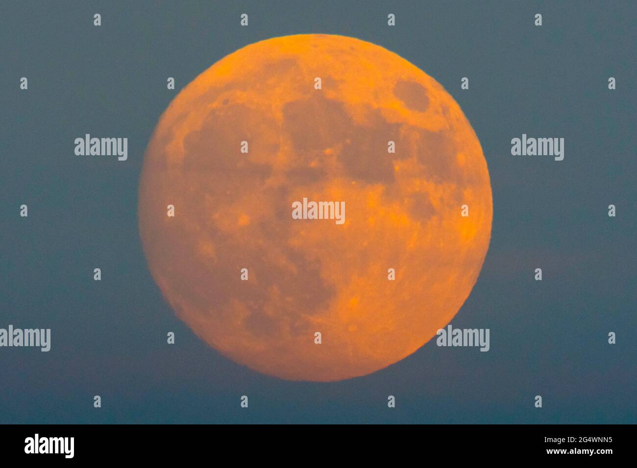 Glastonbury, Somerset, Regno Unito. 23 giugno 2021. Regno Unito Meteo. La quasi piena Strawberry Supermoon nel cielo sereno sopra Glastonbury nel Somerset. Questo mese Strawberry Full Moon è l'ultima Superluna dell'anno. Picture Credit: Graham Hunt/Alamy Live News Foto Stock