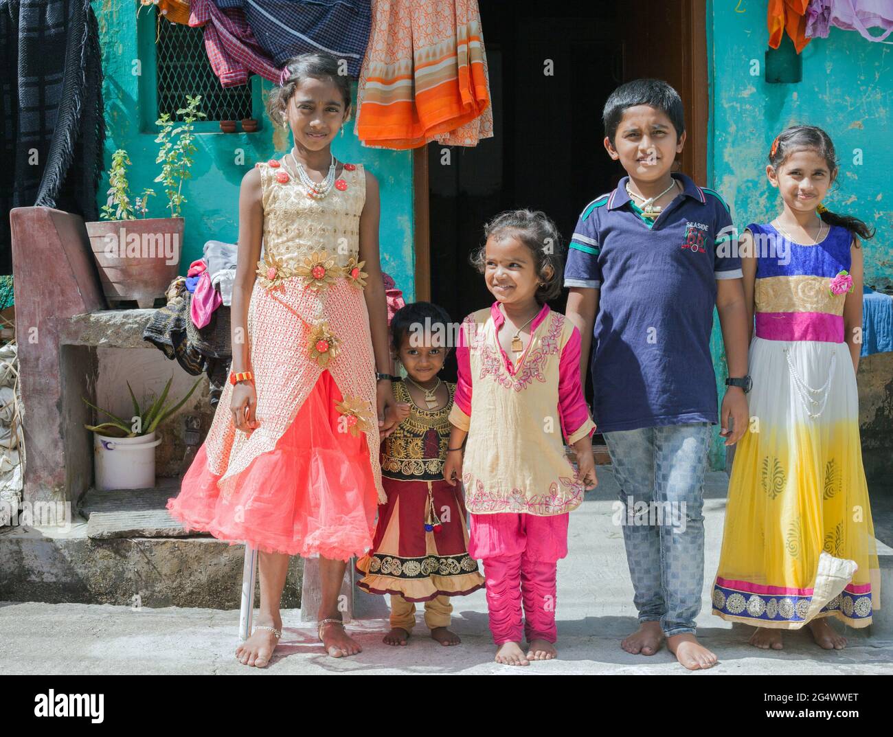 Foto di famiglia di giovani indiani vestiti con intelligenza nei loro galli da festa in posa per la macchina fotografica, Mysore, Karnataka, India Foto Stock