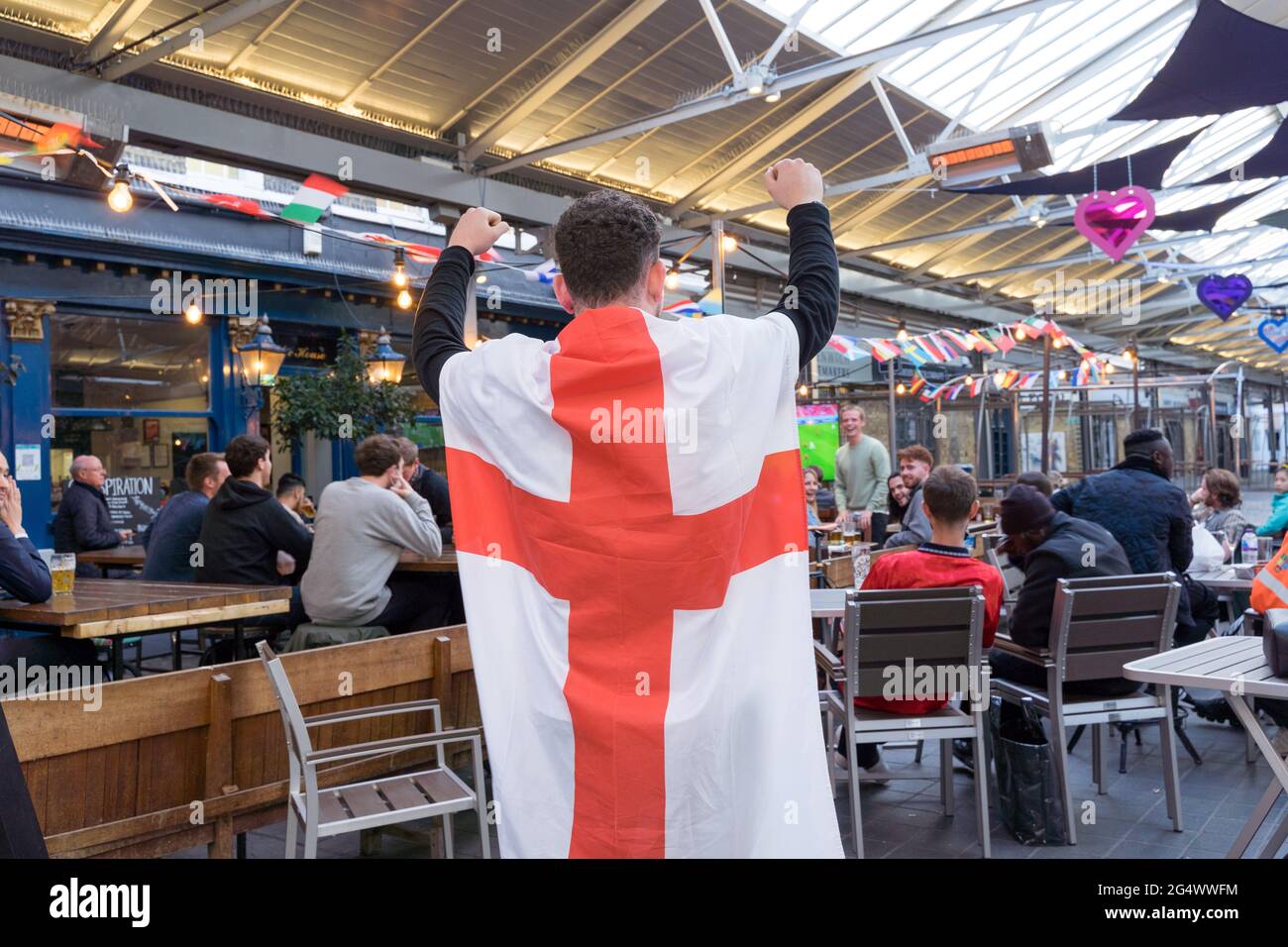 Tifoso inglese con bandiera sulla schiena che watchoing EURO2020 UEFA festival, Pub, greenwich, Londra, Regno Unito Foto Stock