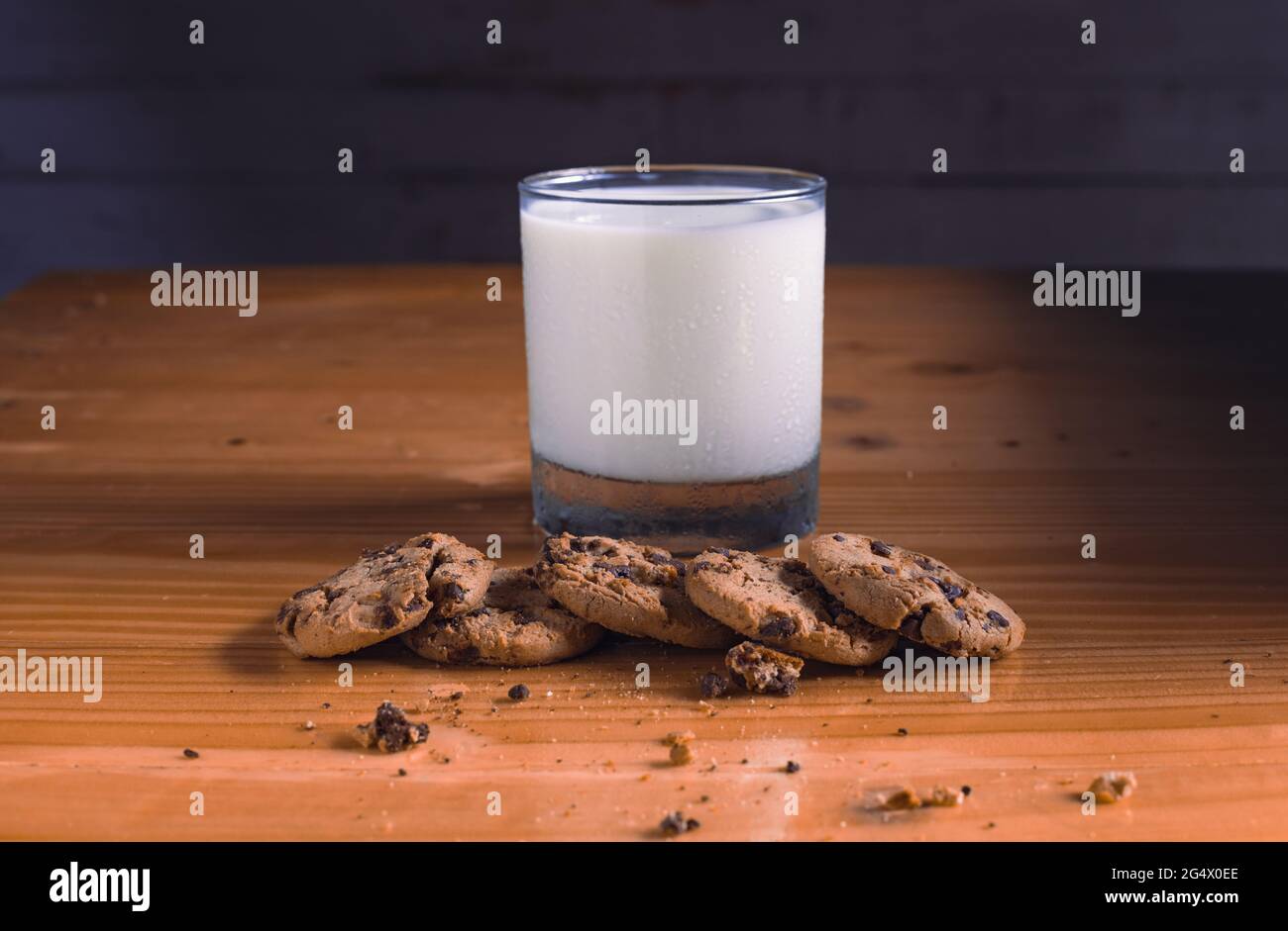 mangiare biscotti al cioccolato mentre si ha un bicchiere di latte Foto Stock