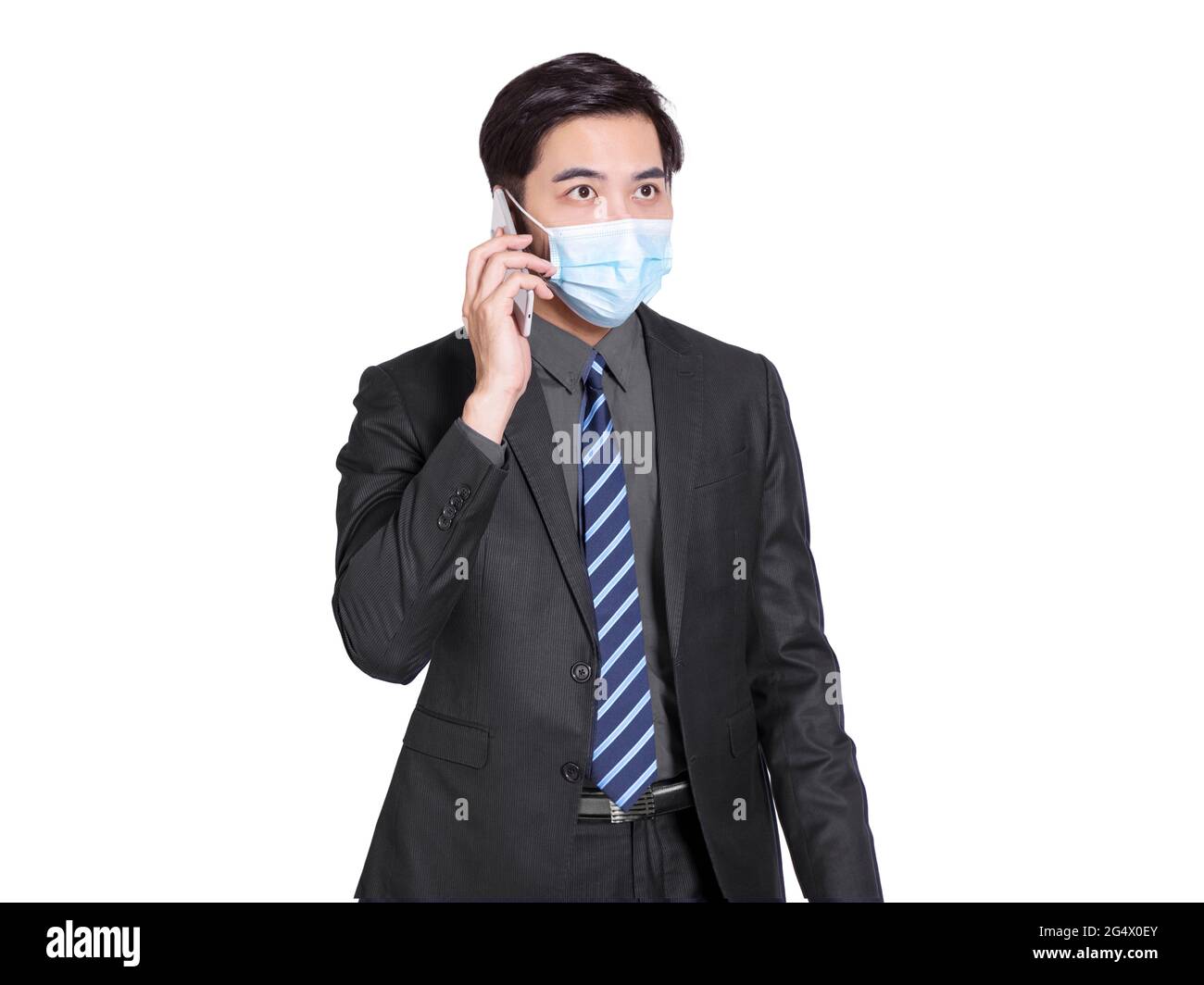 giovane uomo d'affari che indossa una maschera protettiva, utilizzando il telefono cellulare per conversare. Concetto di prevenzione pandemica del coronavirus Foto Stock