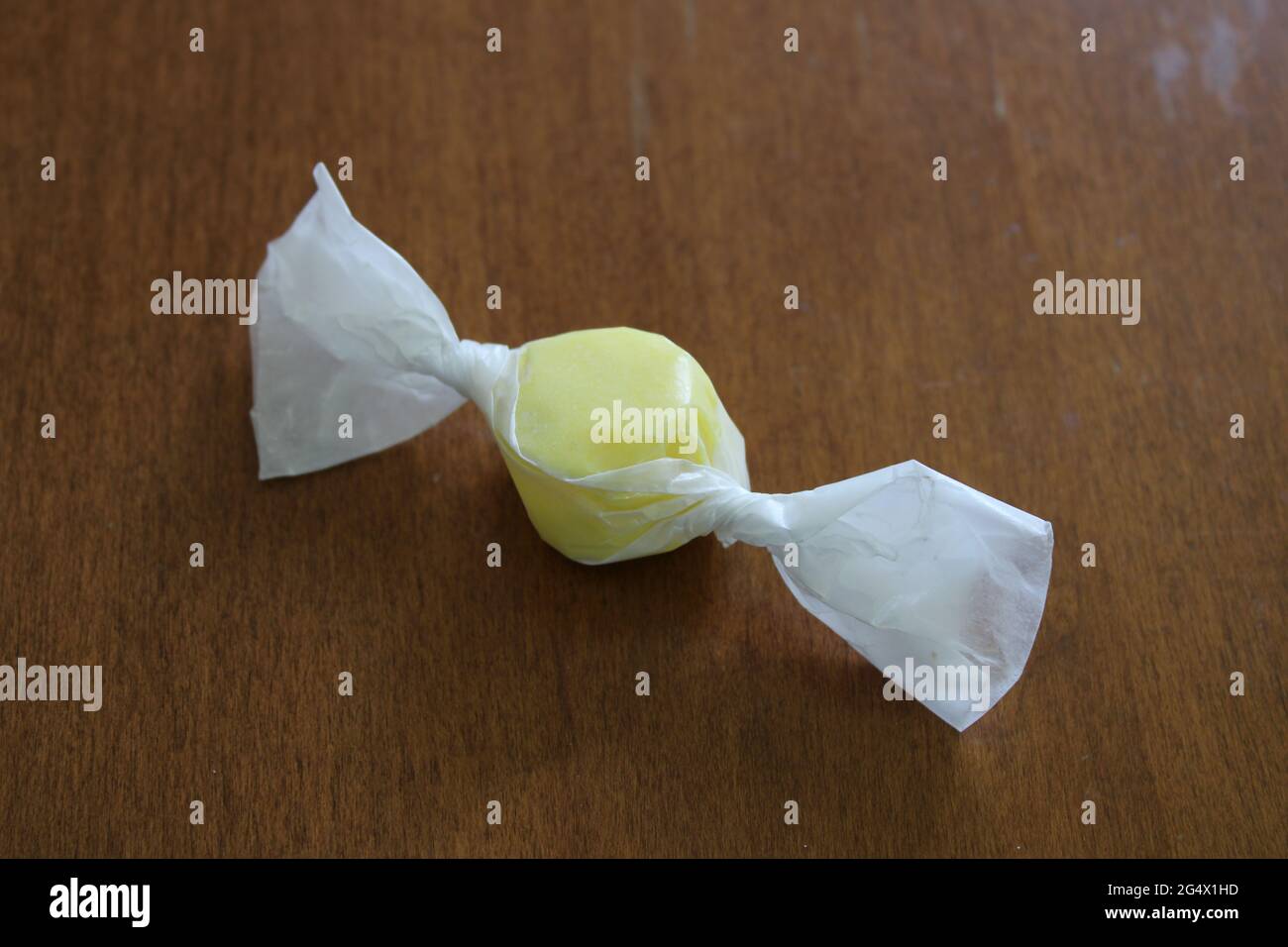 Un singolo pezzo di limone Taffy d'acqua salata vecchio stile avvolto in carta cera Foto Stock