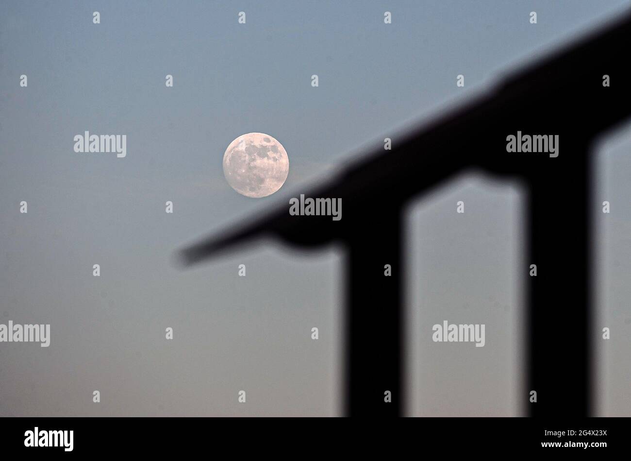 Malaga, Spagna. 23 giugno 2021. p>una luna illuminata è vista sul cielo su una struttura durante la notte di San Giovanni alla spiaggia di Malagueta. Durante la notte del 24 giugno del 2021 si svolgerà l'ultima luna superluna dell'anno corrente, nota come 'la luna piena di mirtillo'. Il suo nome deriva dalla raccolta delle fragole e avviene dopo il solstice estivo.Â Credit: Jesus Merida/SOPA Images/ZUMA Wire/Alamy Live News Foto Stock