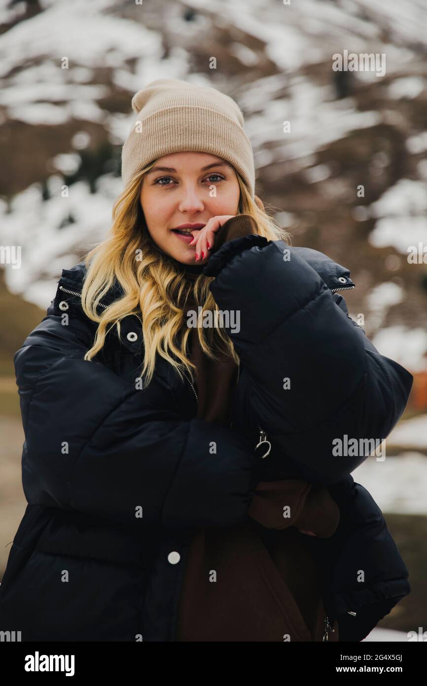 Donna bionda con cappello a maglia di fronte alla montagna della neve Foto  stock - Alamy